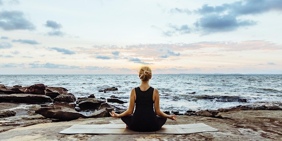 NU A day of Spiritual Renewal: Woman on mat in front of the ocean and horizon NU A day of Spiritual Renewal: Woman on mat in front of the ocean and horizon
